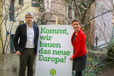 Zwei Personen stehen neben einem Plakat mit dem Titel: "Kommt, wir bauen das neue Europa!"
